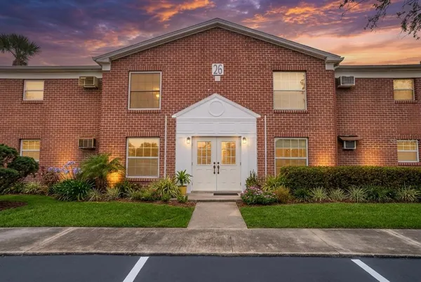 a front view of a house with a yard and outdoor seating
