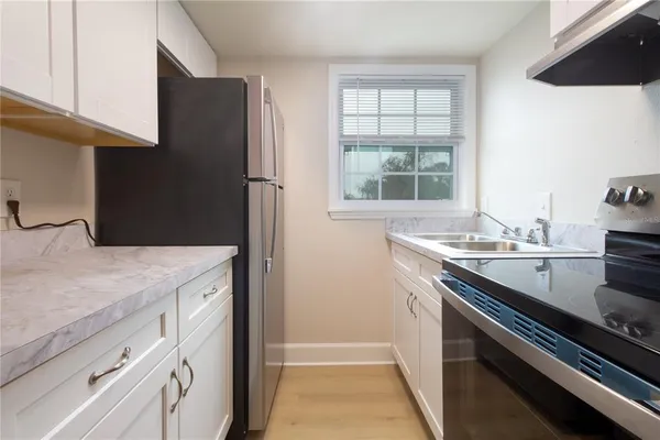 a kitchen with a sink stove and refrigerator