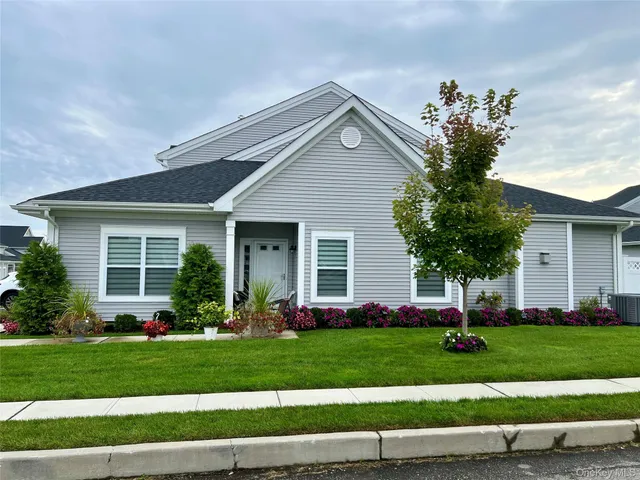 a front view of a house with a garden and plants