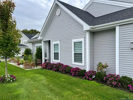 a front view of a house with a yard and outdoor seating