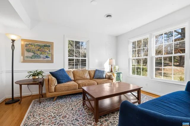 a living room with a black white checkered floor with a gaming machine and dining table