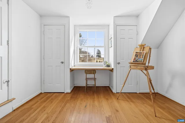 a view of a white house in the middle of a yard