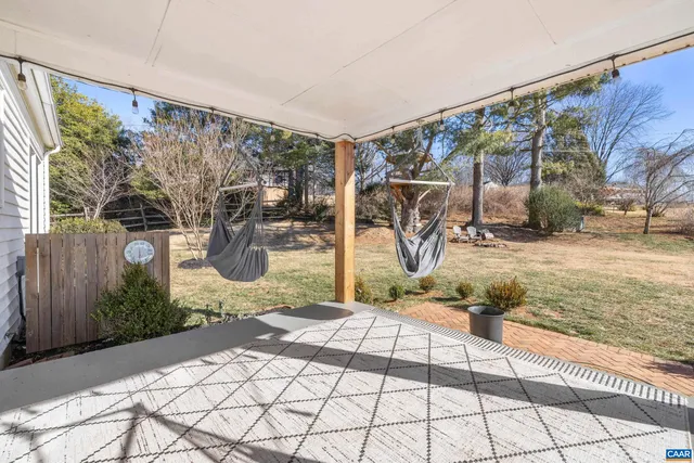 a view of a patio with couches chairs and wooden floor