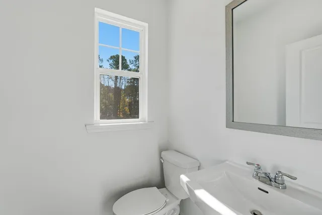 a bathroom with a toilet sink and mirror