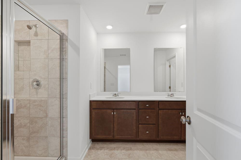 6121 Wayburn Street Tucker, GA 30084 - Photo 21 of 47 a bathroom with a double vanity sink a large mirror and shower