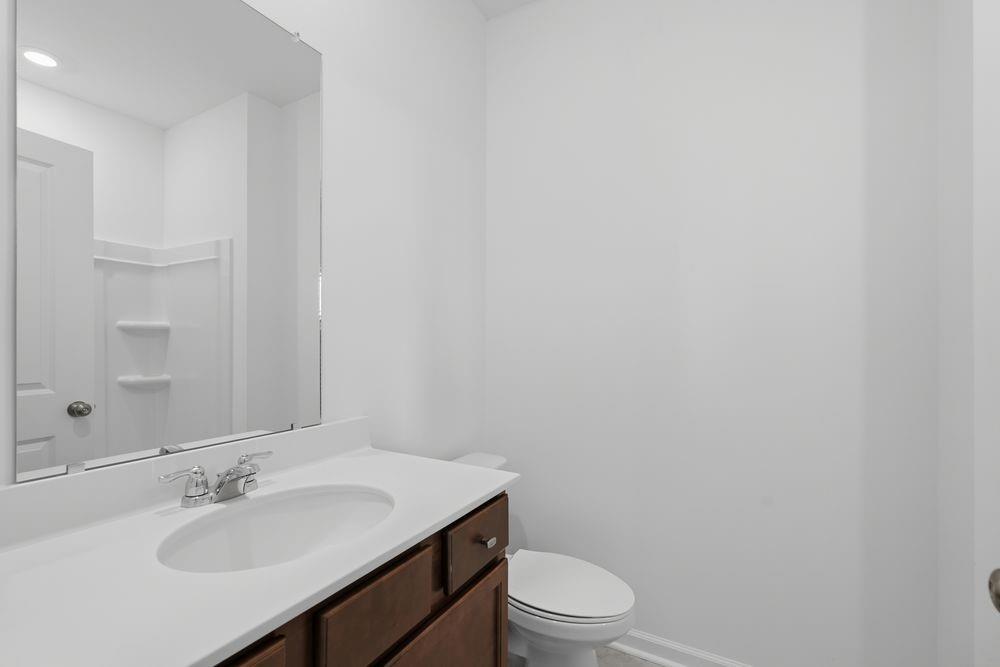 6121 Wayburn Street Tucker, GA 30084 - Photo 4 of 47 a bathroom with a toilet a sink and mirror