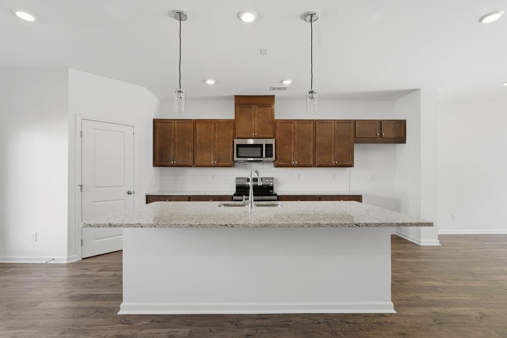 6121 Wayburn Street Tucker, GA 30084 - Photo 5 of 47 a kitchen with kitchen island stainless steel appliances granite countertop a sink a refrigerator and stove