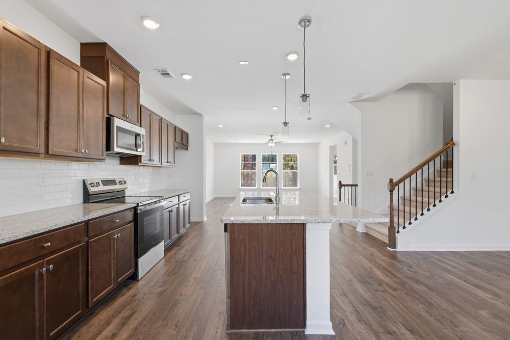 6121 Wayburn Street Tucker, GA 30084 - Photo 6 of 47 a large kitchen with stainless steel appliances lots of counter space and wooden floor
