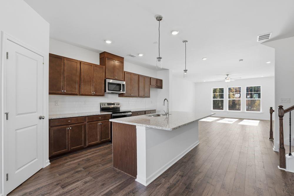 6121 Wayburn Street Tucker, GA 30084 - Photo 9 of 47 a kitchen with stainless steel appliances granite countertop a sink a stove and a wooden floors