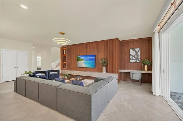 a living room with furniture kitchen view and a large window