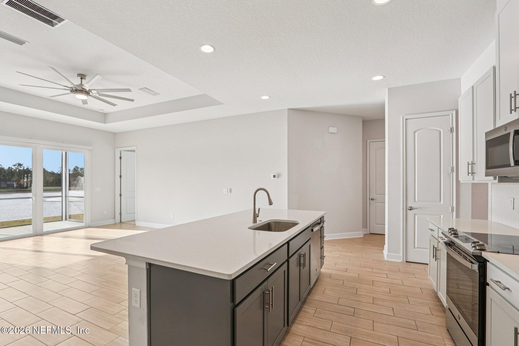 1724 Austin Lk Way Middleburg, FL 32068 - Photo 11 of 61 a kitchen with granite countertop a sink and a refrigerator