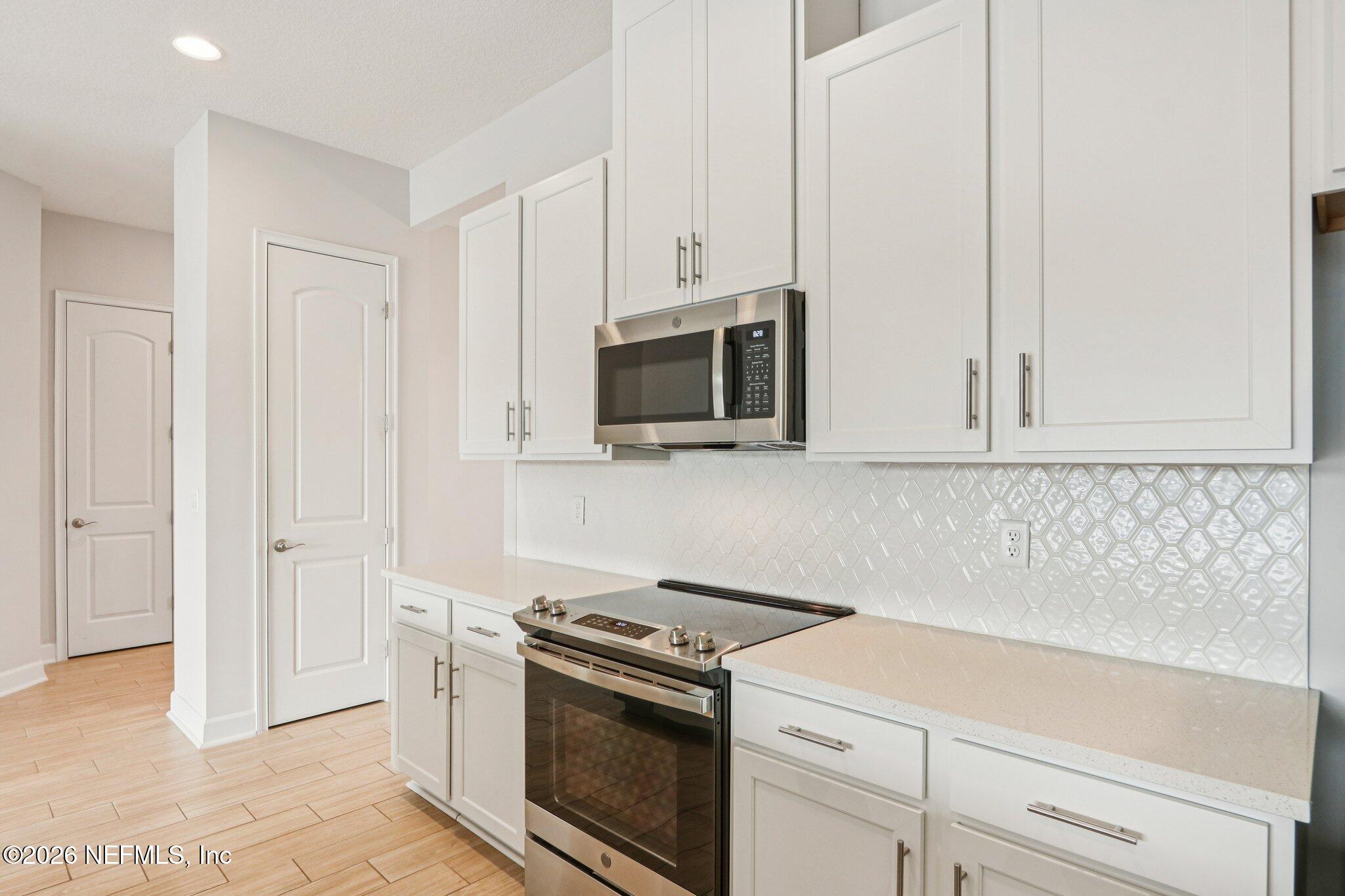 1724 Austin Lk Way Middleburg, FL 32068 - Photo 12 of 61 a kitchen with stainless steel appliances white cabinets and a stove