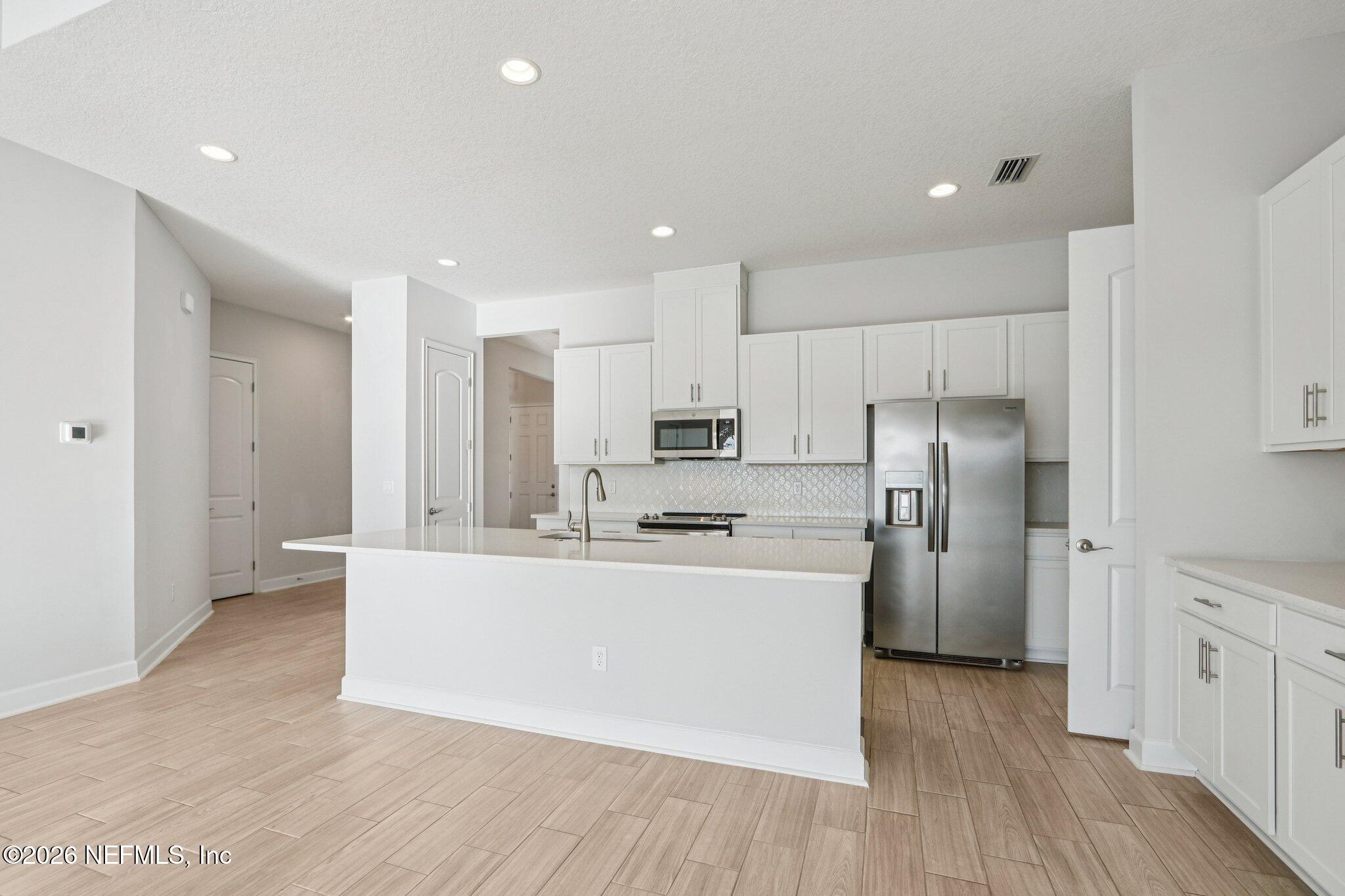 1724 Austin Lk Way Middleburg, FL 32068 - Photo 13 of 61 a large kitchen with stainless steel appliances a refrigerator and a stove top oven