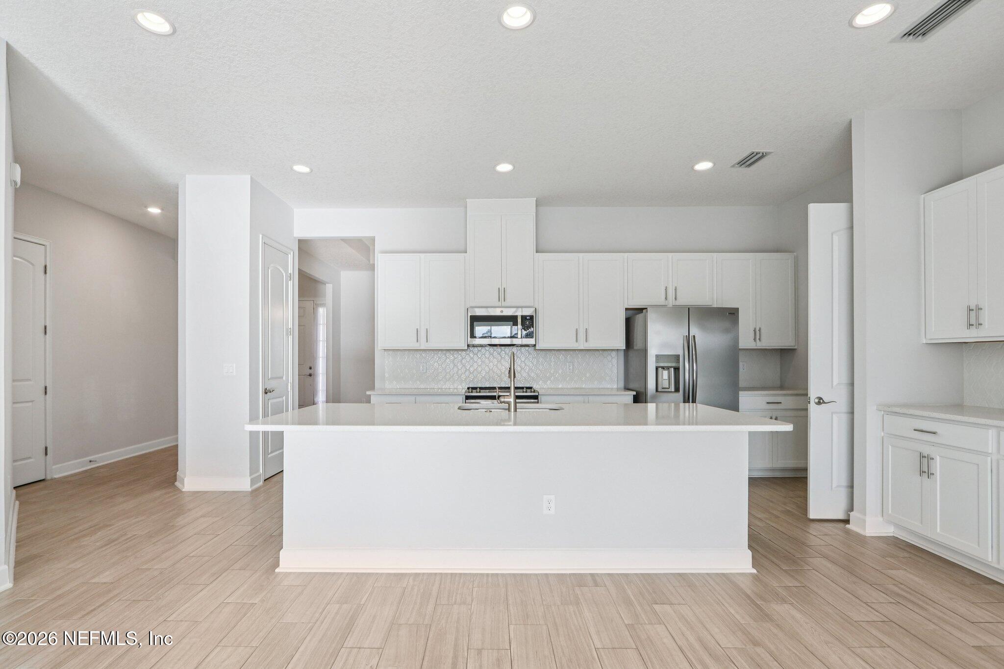 1724 Austin Lk Way Middleburg, FL 32068 - Photo 14 of 61 a large kitchen with stainless steel appliances a sink a refrigerator and a stove