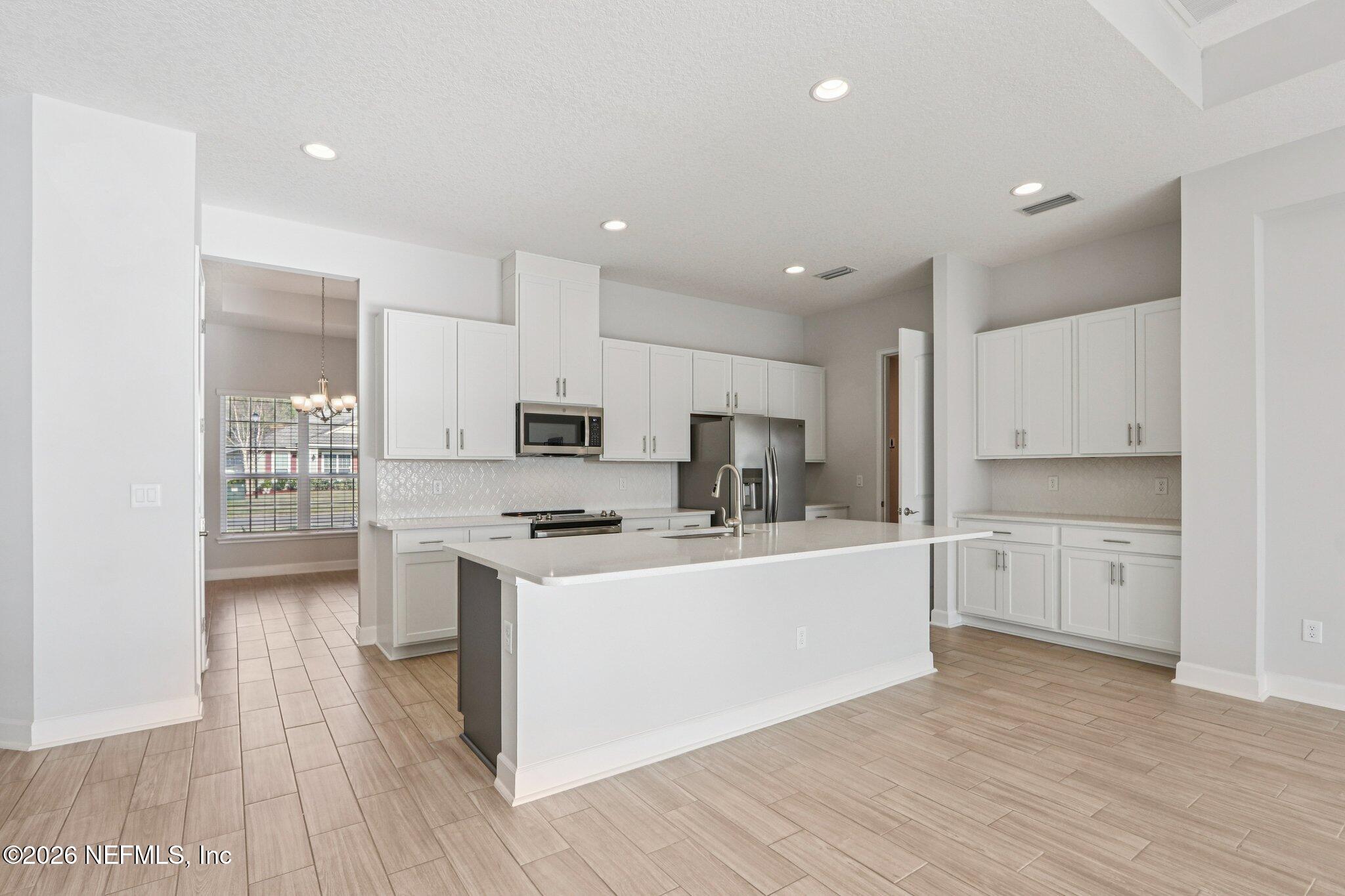 1724 Austin Lk Way Middleburg, FL 32068 - Photo 15 of 61 a kitchen with stainless steel appliances a sink a stove a refrigerator cabinets and a wooden floor