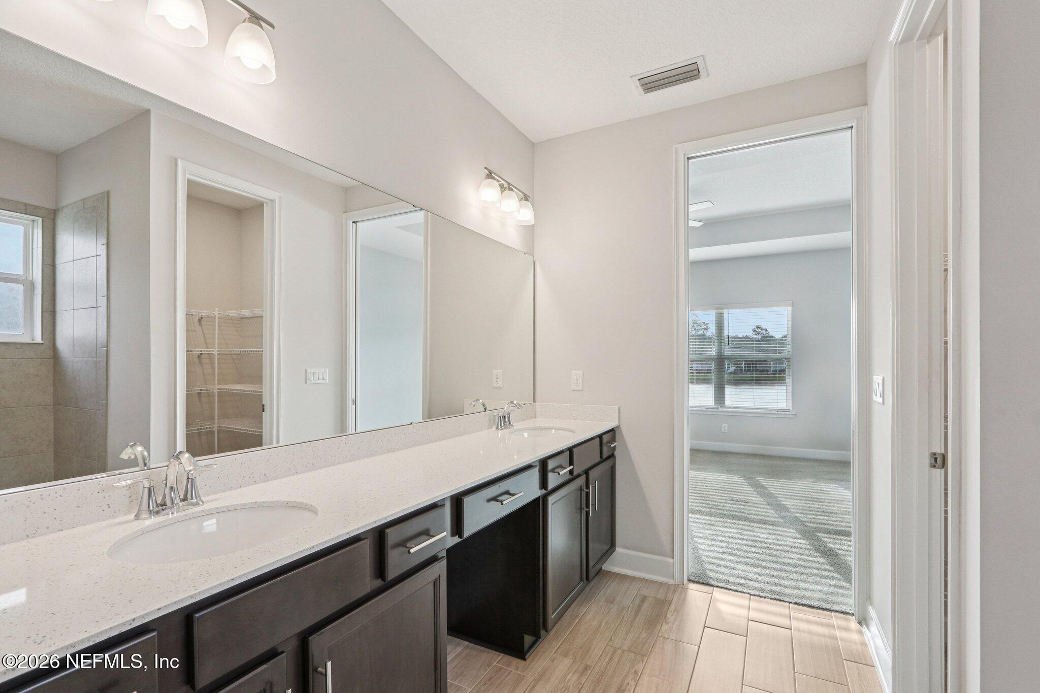 1724 Austin Lk Way Middleburg, FL 32068 - Photo 31 of 61 a bathroom with a double vanity sink and a mirror