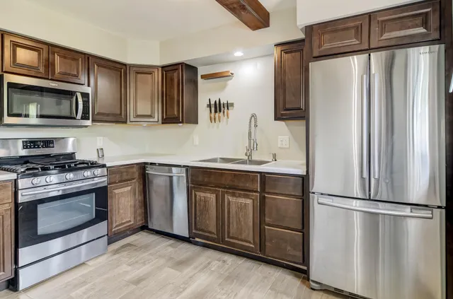 a view of a bedroom with wooden floor and windows