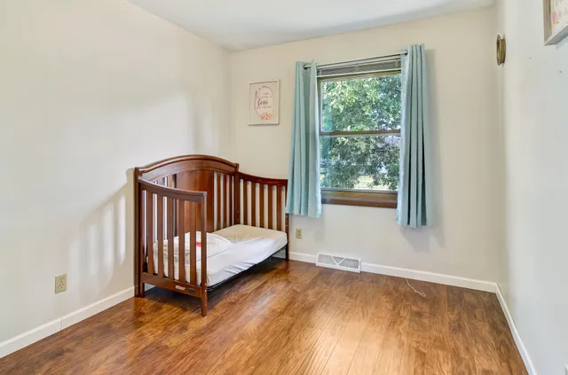 a bedroom with a bed a window and dresser