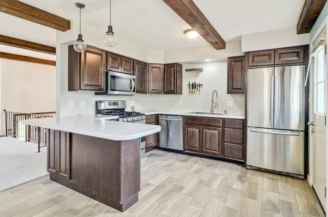 a kitchen with stainless steel appliances granite countertop a stove microwave and cabinets
