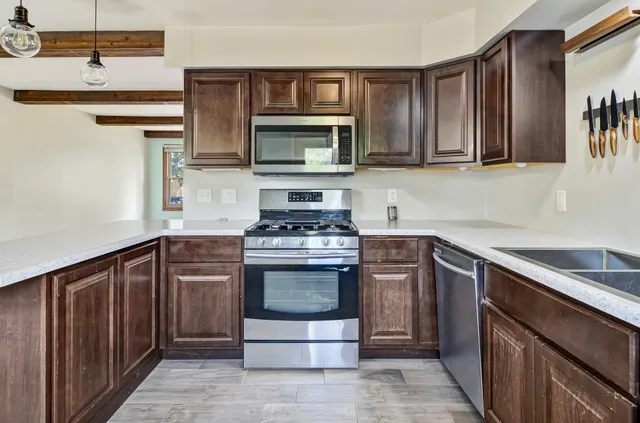a kitchen with stainless steel appliances granite countertop a refrigerator stove and microwave