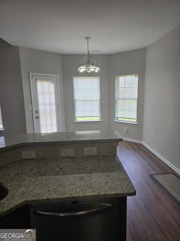 a kitchen with a stove and wooden floor