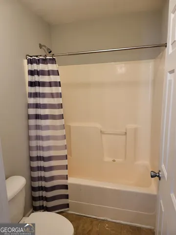 a bathroom with a toilet and a shower