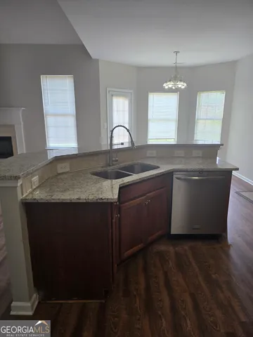 a view of a kitchen counter space a sink wooden floor and window