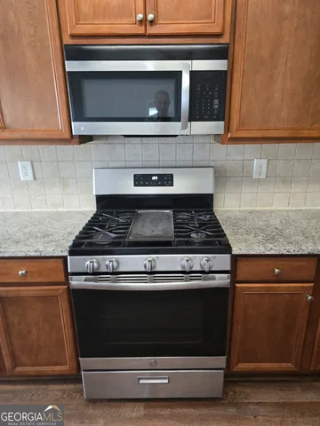 a stove top oven sitting inside of a kitchen