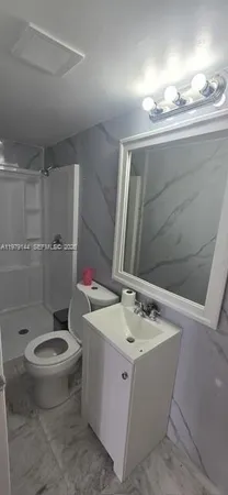 a bathroom with a sink a toilet and shower