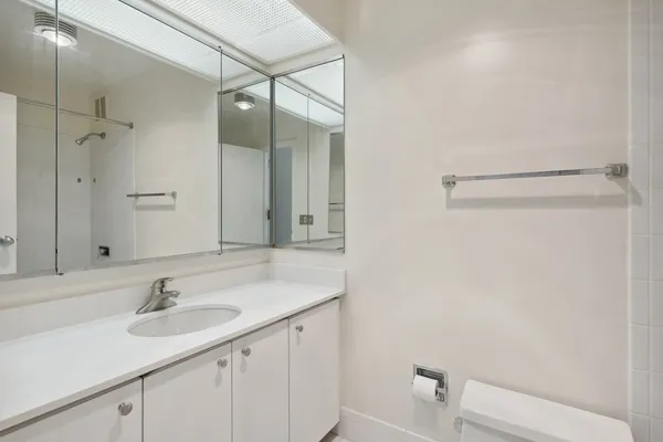 a bathroom with a sink and a mirror with toilet