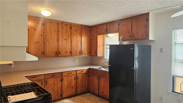 a kitchen with stainless steel appliances granite countertop a refrigerator and a sink