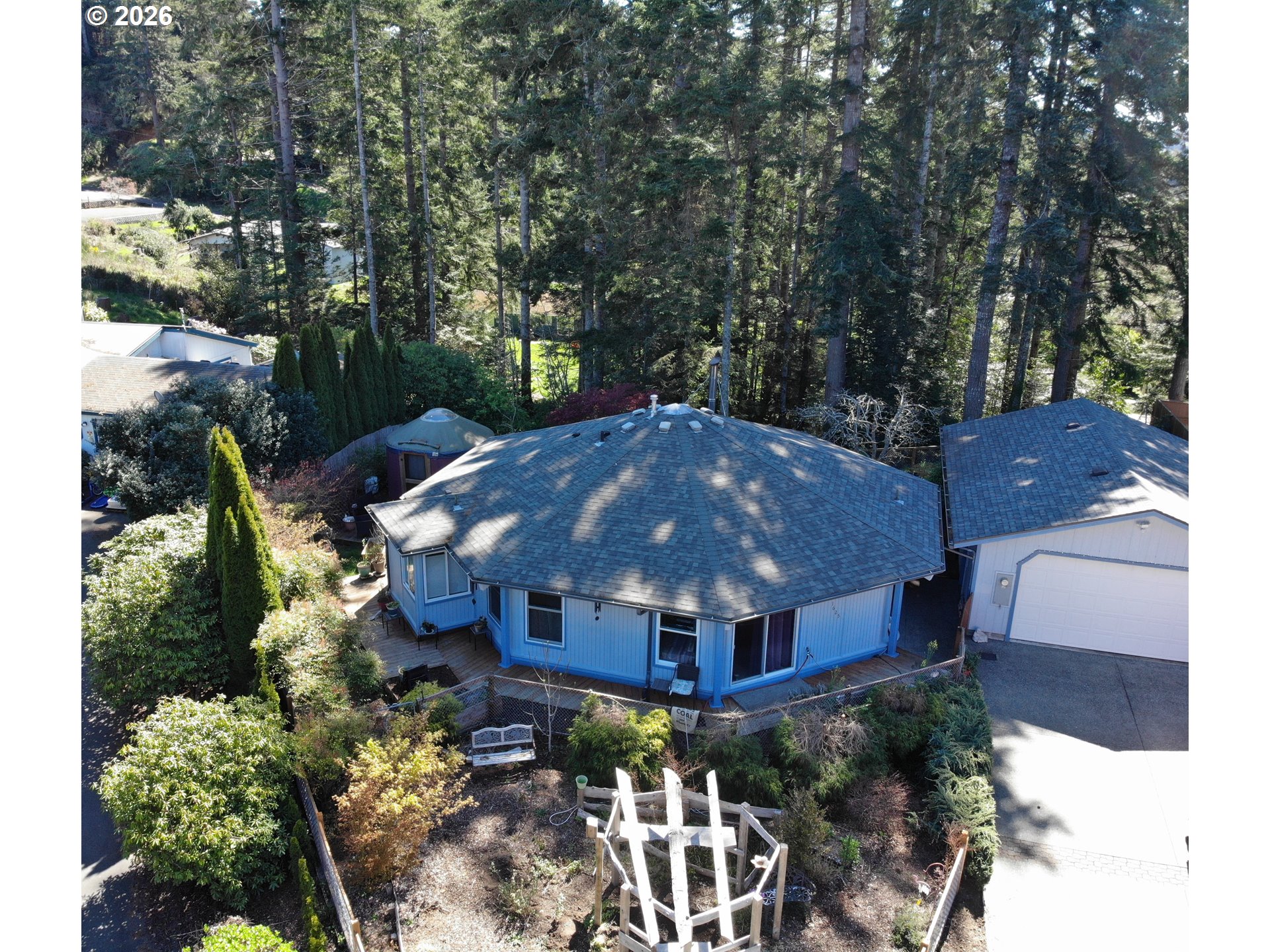 a aerial view of a house with yard and large trees