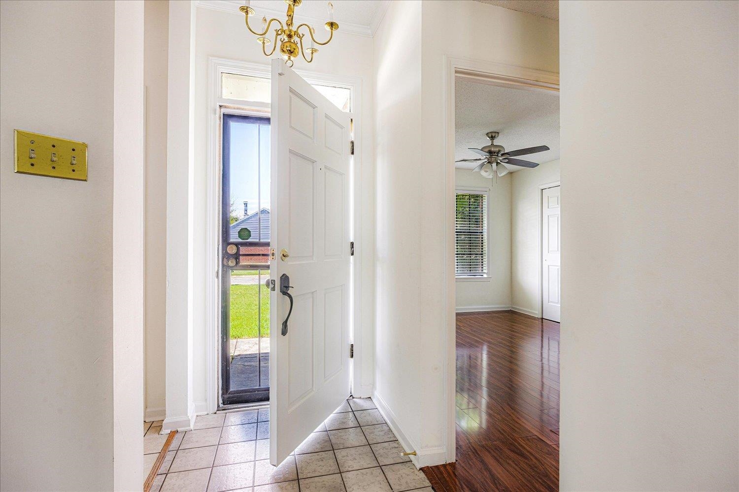 7944 Anne's Circle Memphis, TN 38018 - Photo 6 of 27 a view of a hallway with a dining table and a chandelier fan