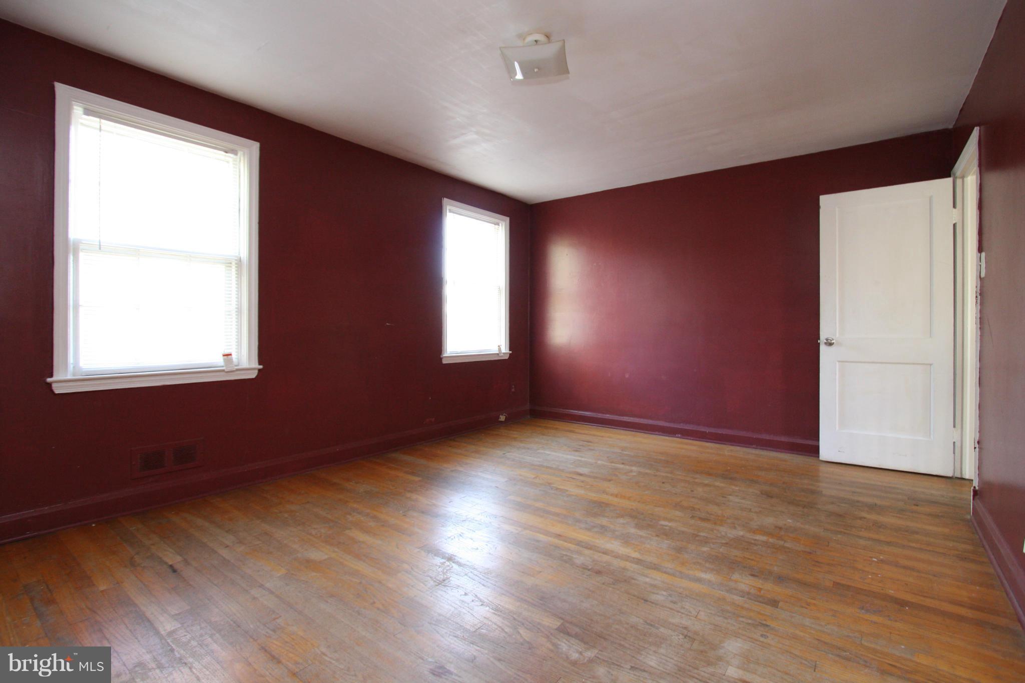 4407 Cedar Garden Road Baltimore, MD 21229 - Photo 11 of 30 an empty room with wooden floor and windows