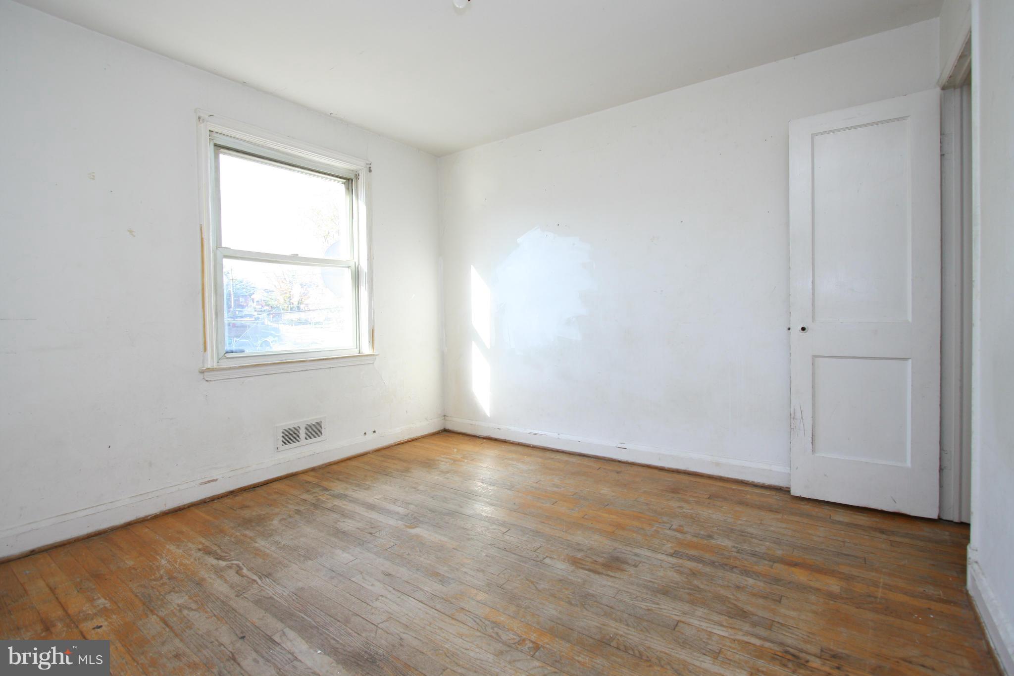 4407 Cedar Garden Road Baltimore, MD 21229 - Photo 17 of 30 an empty room with wooden floor and windows