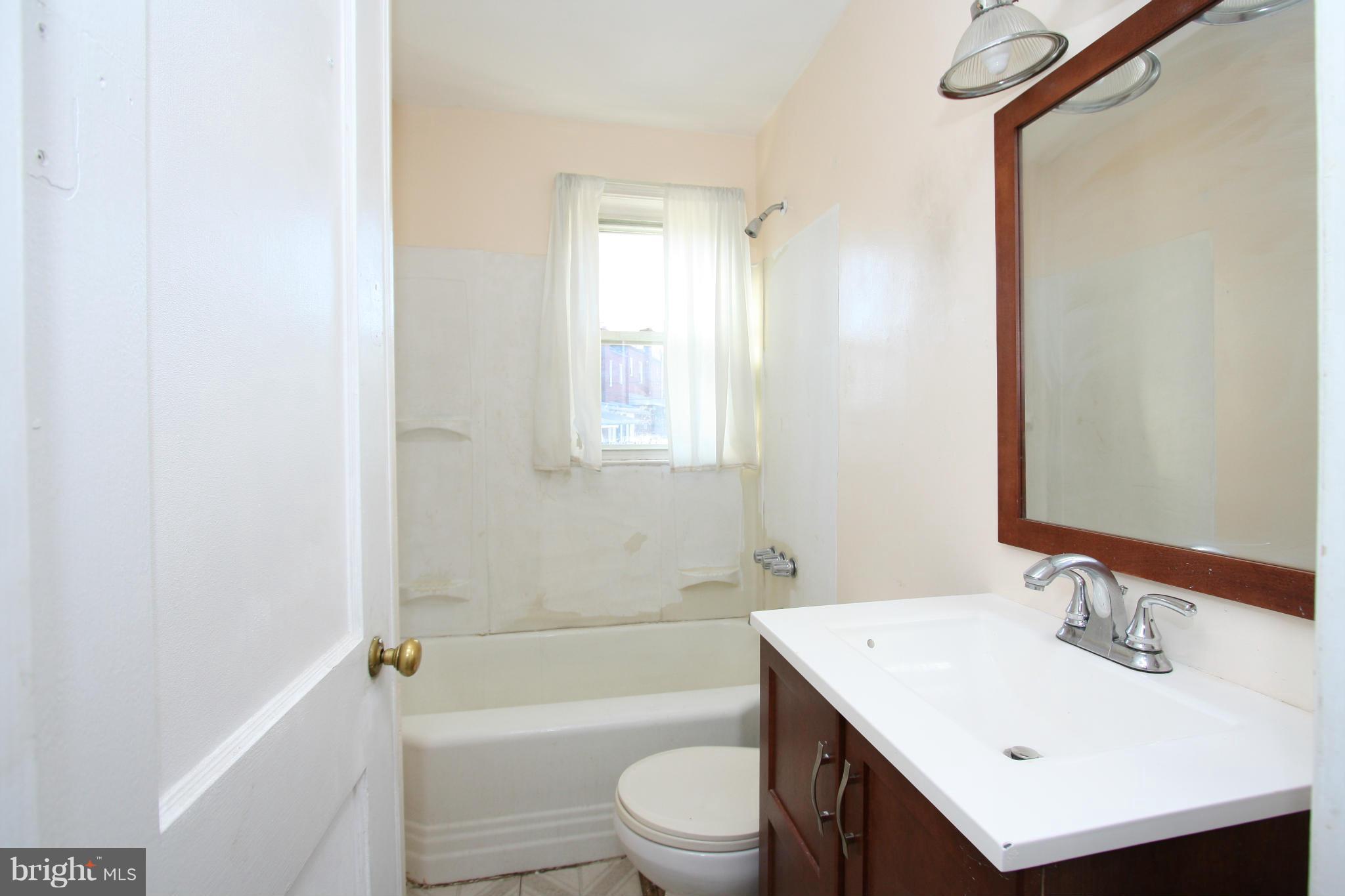 4407 Cedar Garden Road Baltimore, MD 21229 - Photo 19 of 30 a bathroom with a sink a toilet and shower