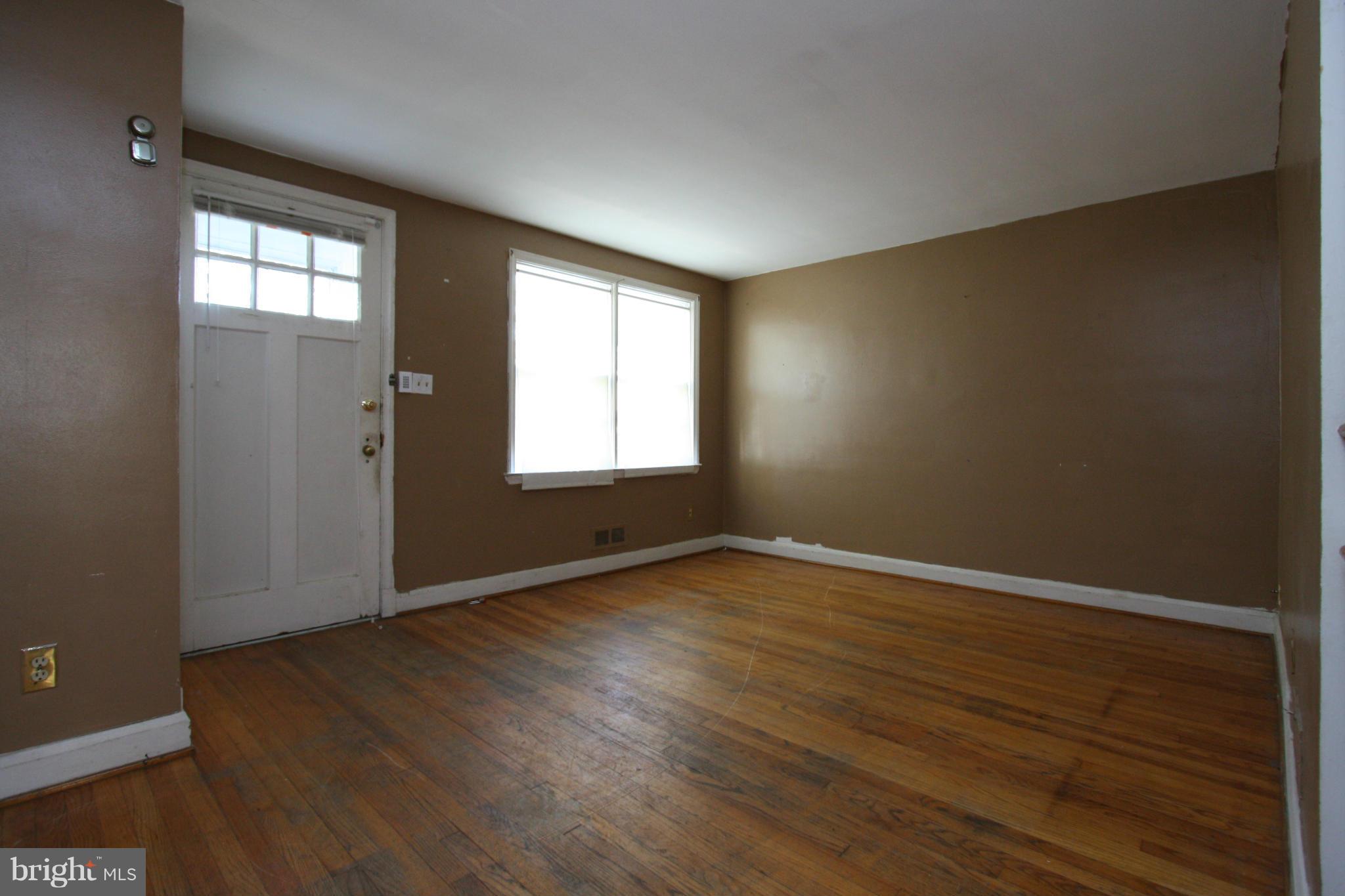 4407 Cedar Garden Road Baltimore, MD 21229 - Photo 5 of 30 an empty room with wooden floor and windows
