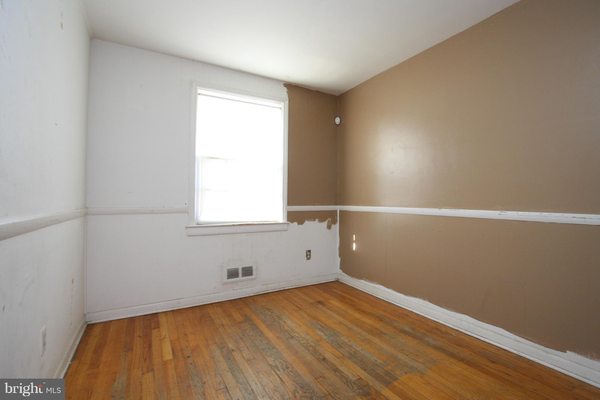4407 Cedar Garden Road Baltimore, MD 21229 - Photo 7 of 30 an empty room with wooden floor and windows