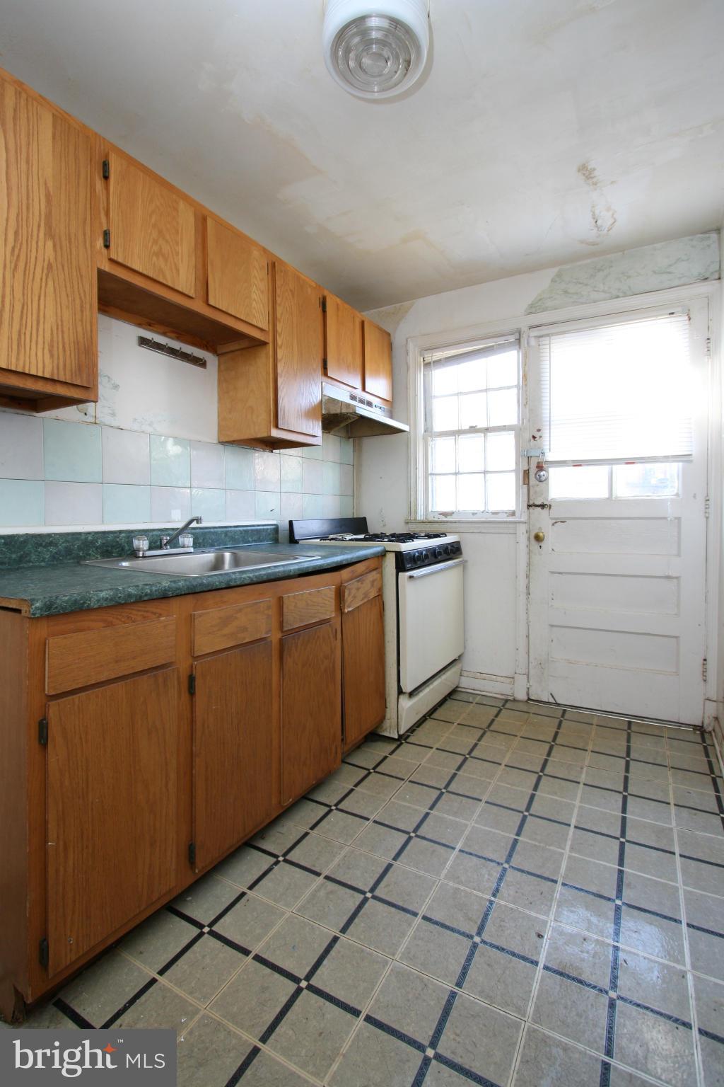 4407 Cedar Garden Road Baltimore, MD 21229 - Photo 10 of 30 a kitchen with a sink a stove and cabinets