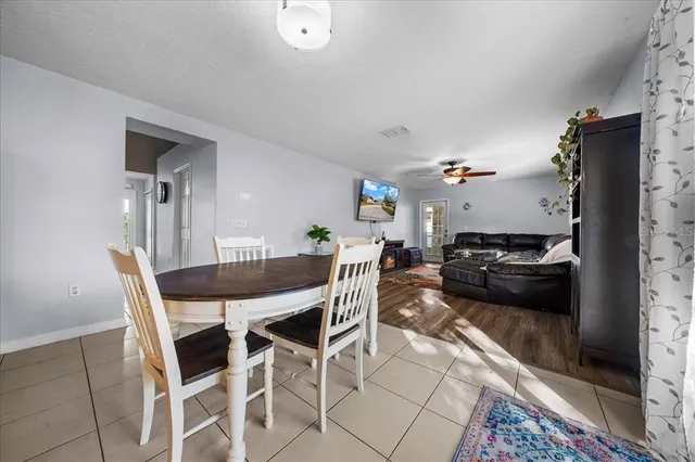 a kitchen with stainless steel appliances granite countertop a stove top oven a sink dishwasher and white cabinets with wooden floor