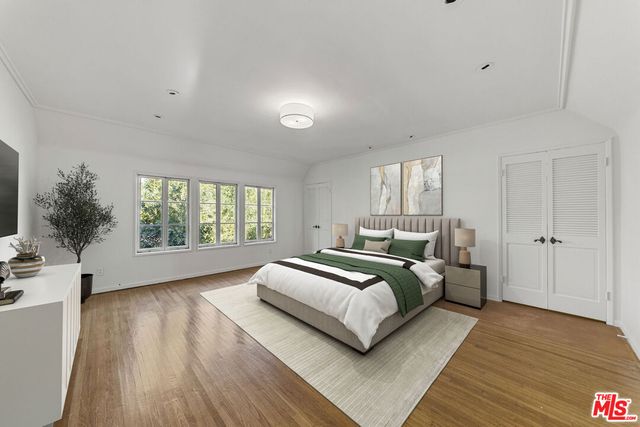 a spacious bedroom with a bed and a large window