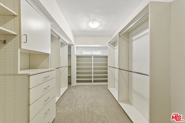 a view of walk in closet with empty racks