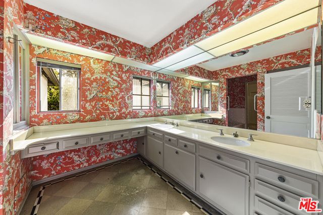 a bathroom with a granite countertop sink and a large mirror