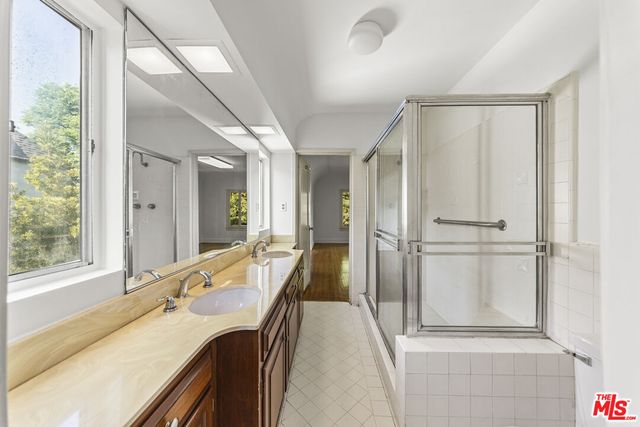 a bathroom with a granite countertop sink and a large mirror