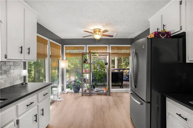 a open kitchen with granite countertop a refrigerator a stove and a sink with granite countertops