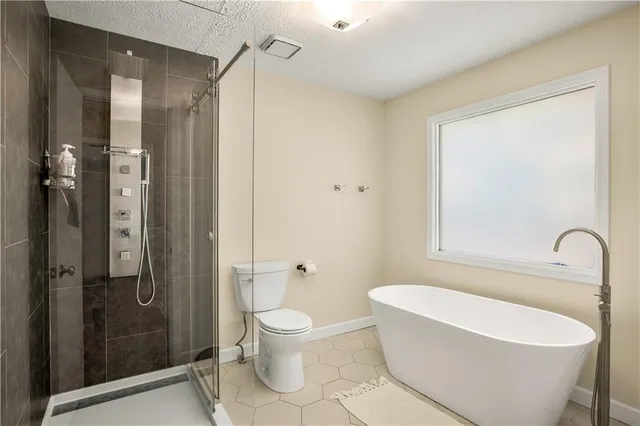 a bathroom with a white bath tub a mirror and a shower