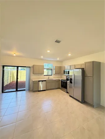 a view of kitchen with stainless steel appliances a refrigerator and a sink