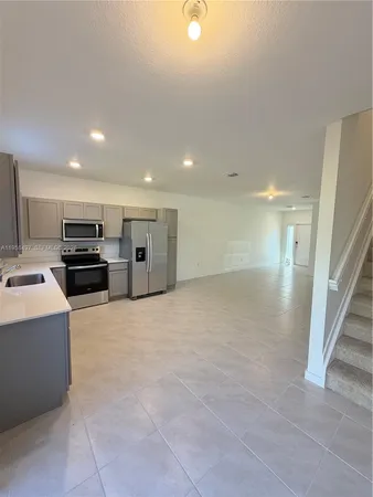 a view of kitchen with refrigerator and stove