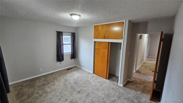 an empty room with closet and entryway
