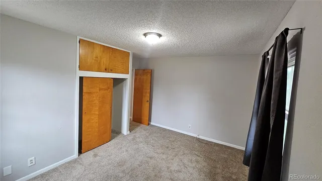 an empty room with closet and a window